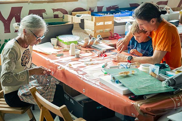 Transmission des gestes d'un parent à un enfant lors des ateliers participatifs de Bidart. Moment intergénérationnel